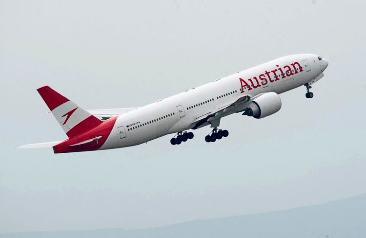 Ein Flugzeug der Austrian Airlines im Steigflug nach dem Start am internationalen Flughafen Wien in Schwechat, Österreich. Das Flugzeug ist weiß mit roten Akzenten und dem Schriftzug 