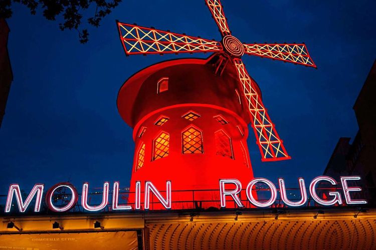 Moulin Rouge Windräder leuchtend bei Nacht.