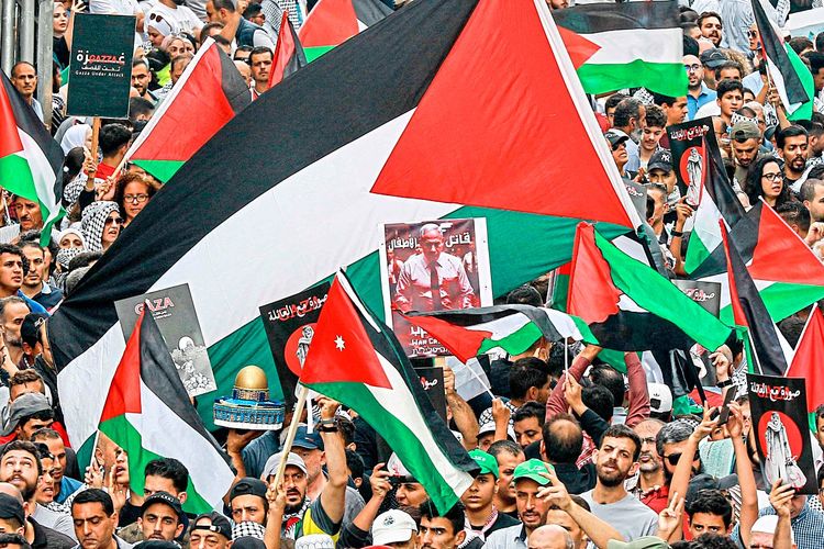 Jordanische Demonstranten schwingen die Fahne von Palästina und fordern ein Ende der israelischen Angriffe.