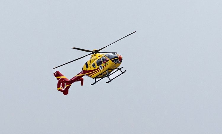 Ein gelber Rettungshubschrauber mit roten Markierungen, bezeichnet als 