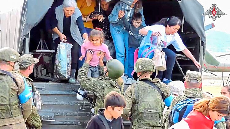 Russische Friedenstruppen bringen im Zuge einer Evakuierung Zivilisten aus Stepanakert in Sicherheit.