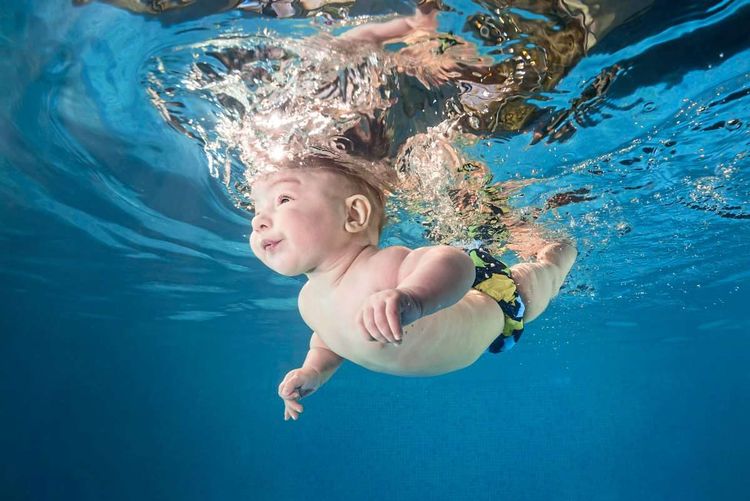 Ein lächelndes Baby unter Wasser