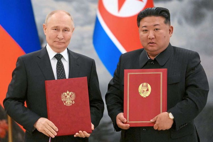 Putin (links), Kim (rechts) halte jeweils eine Mappe in die Kamera, im Hintergrund die Flaggen Russlands und Nordkoreas