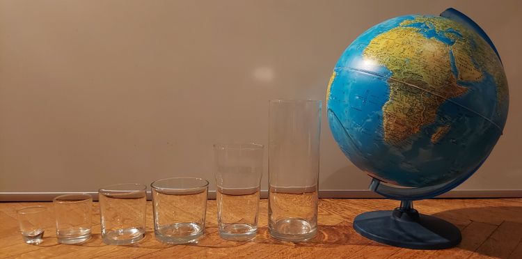 picture of glass containers of different sizes next to globe