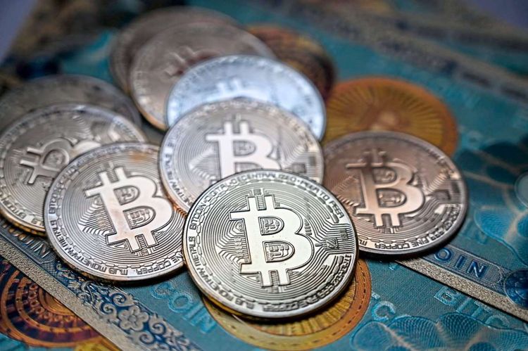 Das Bild zeigt symbolische Bitcoin-Münzen und -Scheine.