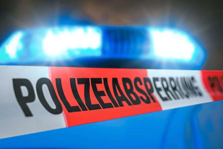 Polizeiabsperrung Absperrband vor einem Polizei Auto mit Blaulicht