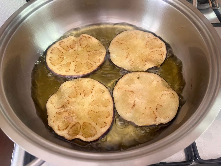 Melanzani in einem Topf mit viel Olivenöl