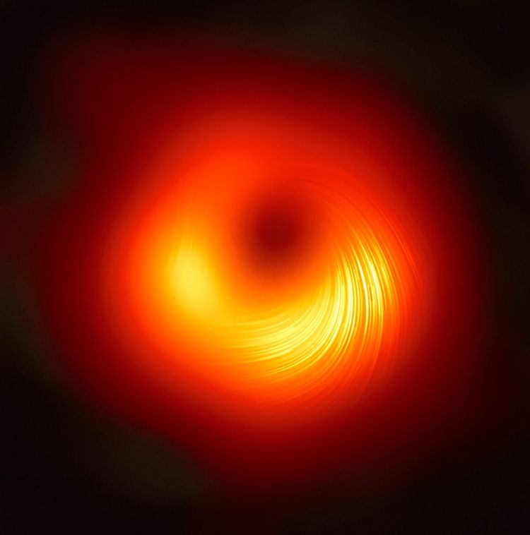 Bild eines von einem rötlichen Ring aus Licht umgebenen Schwarzen Loch