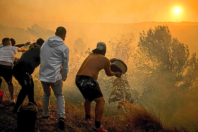 Bewohner in Cacais, Portugal, versuchen ein Feuer zu löschen.