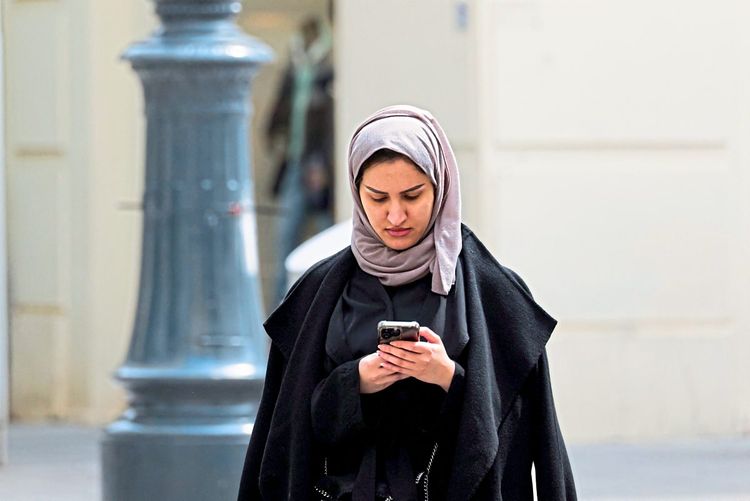 Ein junge Muslimin mit Smartphone