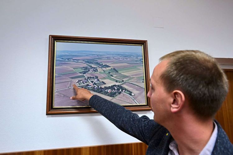 Florian Hofmann zeigt auf eine Luftaufnahme der Gemeinde Pernersdorf