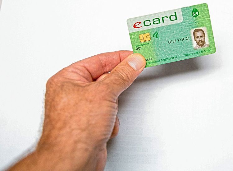 Eine Hand hält eine E-Card mit Foto