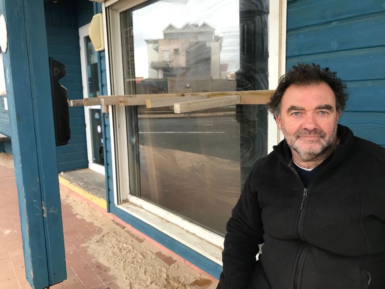 Hervé Cazenave, Mann in schwarzer Pulloverjacke sitzt vor blauem Haus