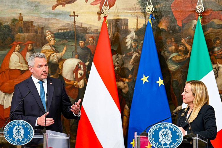 Nehammer und Meloni an Rednerpulten vor den Flaggen Österreichs, Italiens und der EU