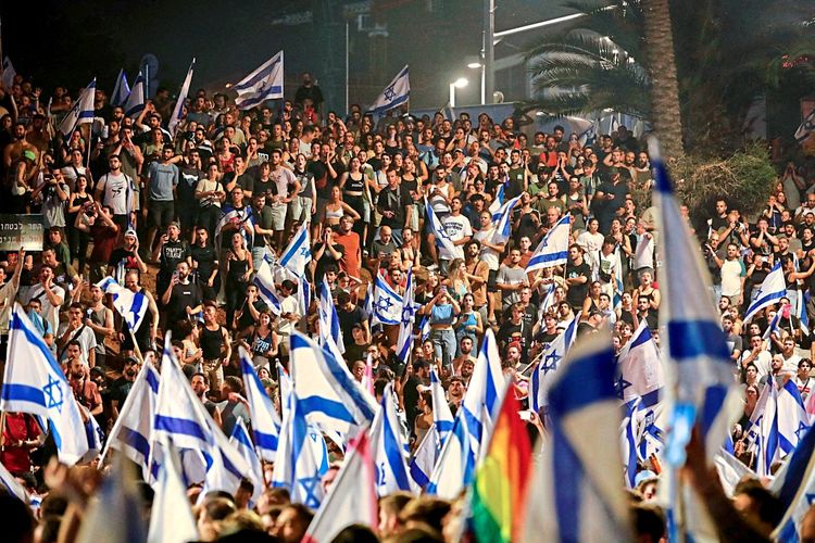 Menschenmenge bei einem Protest, im Vordergrund Dutzende Israel-Flaggen