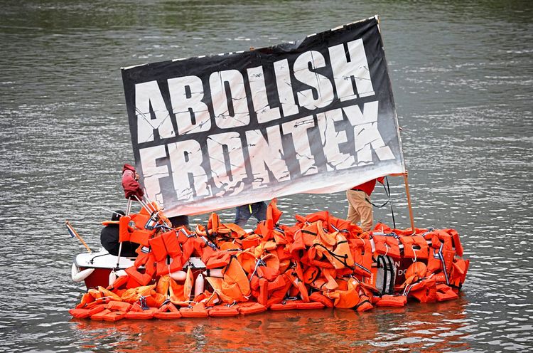 Protest gegen Frontex mittels einem Boot aus Schwimmwesten. Der Slogan ist: Abolish Frontex.  