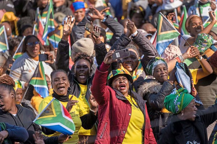 Menschen mit Südafrika-Flaggen klatschen und jubeln.