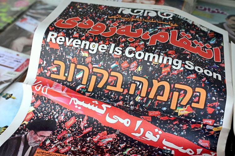 Eine iranische Tageszeitung mit der Schlagzeile „Revenge is coming soon“ (Rache kommt bald) in Englisch, Persisch und Hebräisch, zeigt ein Bild einer Menschenmenge mit roten Fahnen sowie ein Foto des iranischen Führers Ayatollah Mojtaba Khamenei. Die Zeitung liegt auf einem Kiosk in Teheran, Iran, am 12. Juli 2026 aus.
