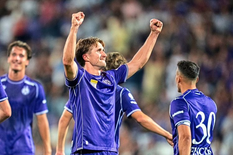 Ein jubelnder Fußballspieler des FK Austria Wien (Reinhold Ranftl) reißt die Arme in die Luft, um ein Tor zu feiern. Im Hintergrund sind Mitspieler und unscharf abgebildete Zuschauer im Stadion zu sehen.