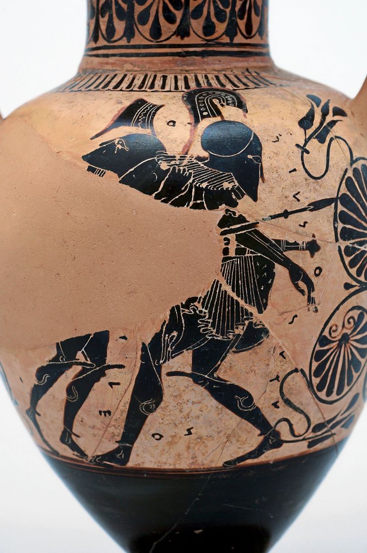 Eine antike griechische Keramikvase im schwarzfigurigen Stil, die eine Kampfszene zeigt. Zwei Krieger mit Helmen, Schilden und Speeren kämpfen gegeneinander. Die Details der Figuren sind sorgfältig eingeritzt und gemalt. Begleitende griechische Inschriften sind sichtbar.