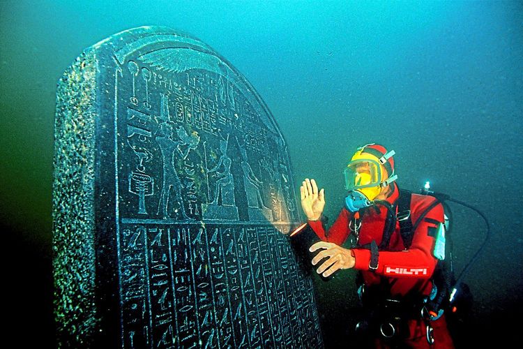 Franck Goddio untersucht einen mit Hieroglyphen versehenen Granitstein unter Wasser.