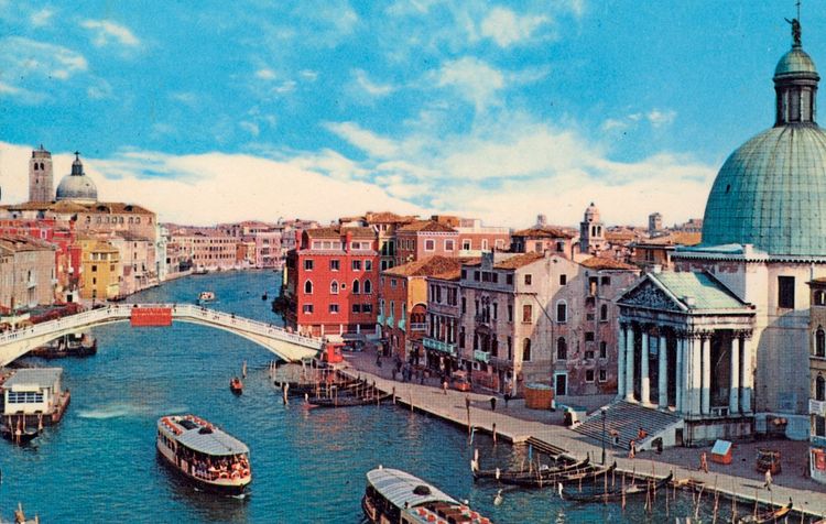 Postkarte von 1952 zeigt den Canal Grande in Venedig, Italien, mit der Ponte degli Scalzi im Vordergrund. Rechts ist die Kirche San Simeone Piccolo sichtbar, im Hintergrund die Kirche San Geremia. Verschiedene Boote sind auf dem Kanal unterwegs, und die Szene ist von historischen Gebäuden umgeben. Der Himmel ist klar und blau.