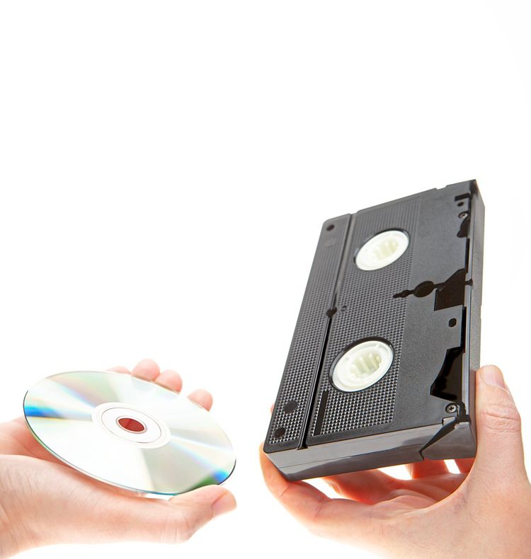 Jemand hält eine DVD und eine VHS-Kassette in den Händen.