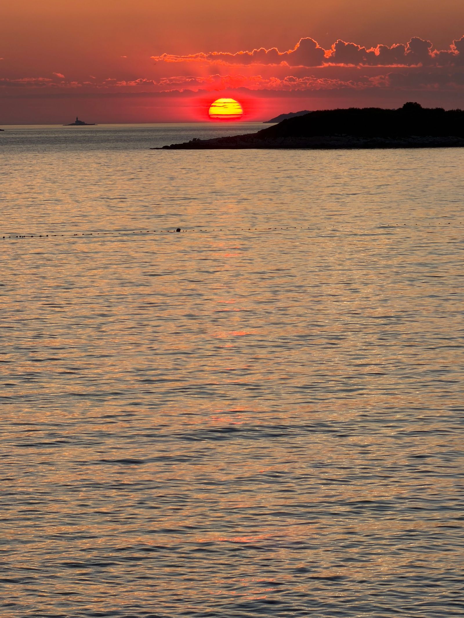 Die Sonne versinkt rotglühend am Horizont des Meeres