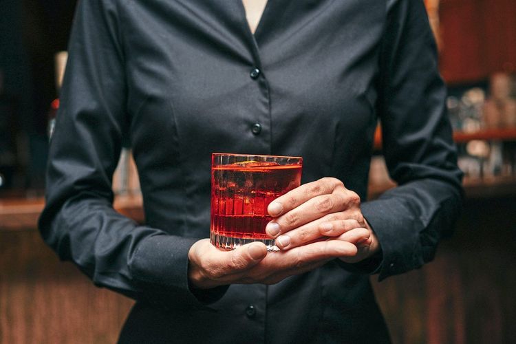 Barkeeperin Sigrid Schot hält einen roten Drink mit beiden Händen