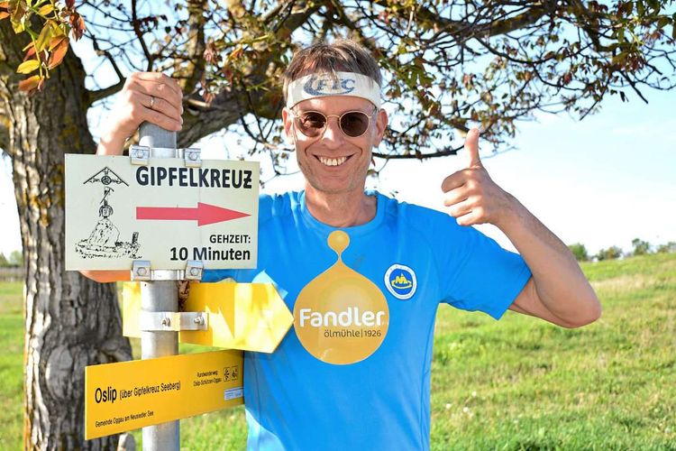 Rolf Majcen beim Wegweiser zum Gipfelkreuz in Oggau.