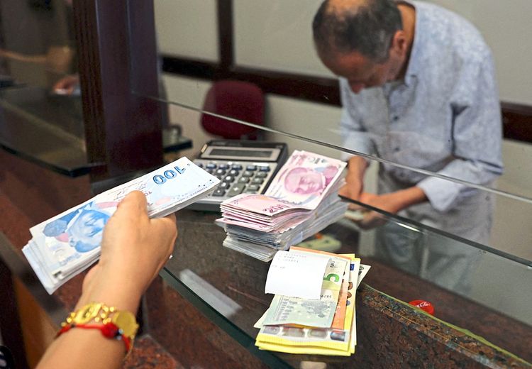 Eine Kundin kauft in einer Wechselstube in Ankara Dollar.