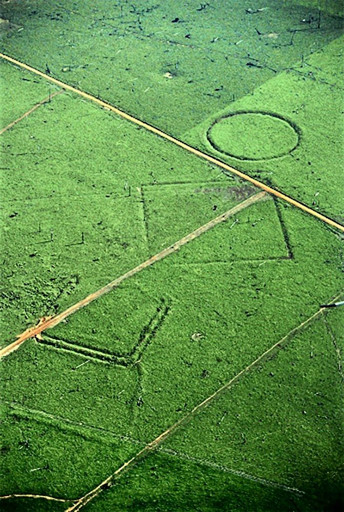 Luftaufnahme von geometrischen Erdwerken (ein Kreis und ein Rechteck) in einem entwaldeten Gebiet in der Region Rio Branco, Bundesstaat Acre, Brasilien. Sie deuten auf hohe Bevölkerungszahlen im präkolumbischen Amazonastiefland hin.