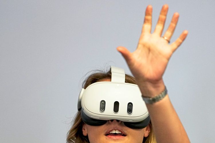 Das Bild zeigt eine Frau, die die Virtual-Reality-Brille Meta Quest 3 trägt