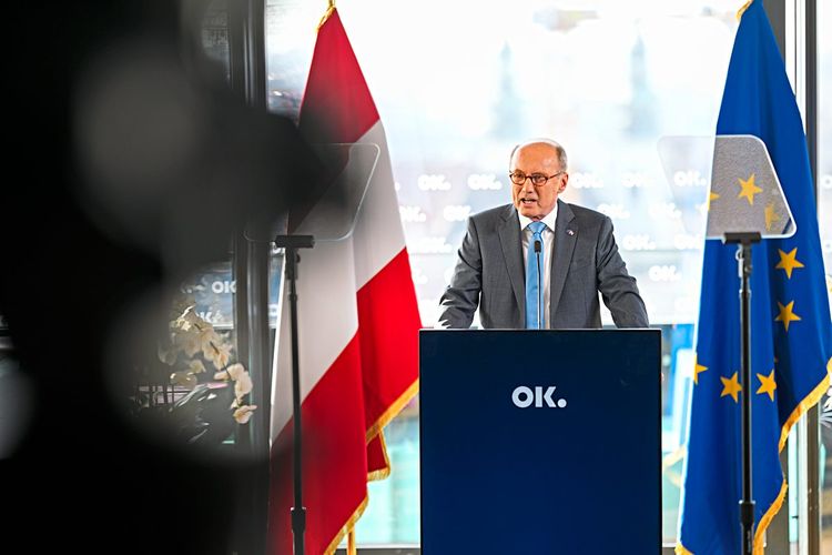 Othmar Karas hinter einem Rednerpult, flankiert von der österreichischen Flagge und jener der EU.