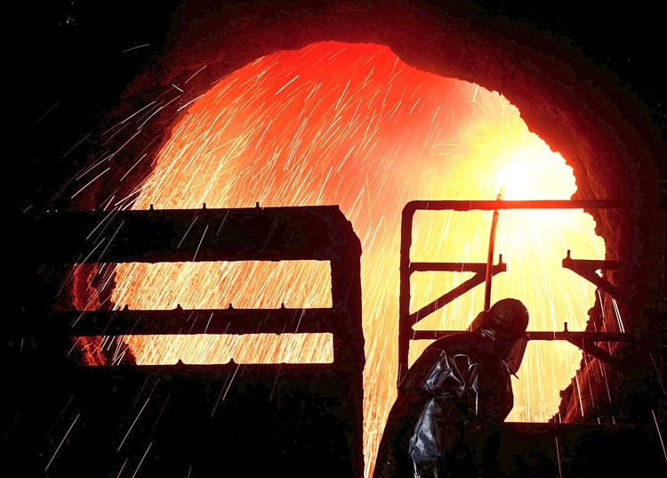 Ein Stahlarbeiter reinigt einen Zylinder im Stahlwerk Salzgitter in Deutschland. 