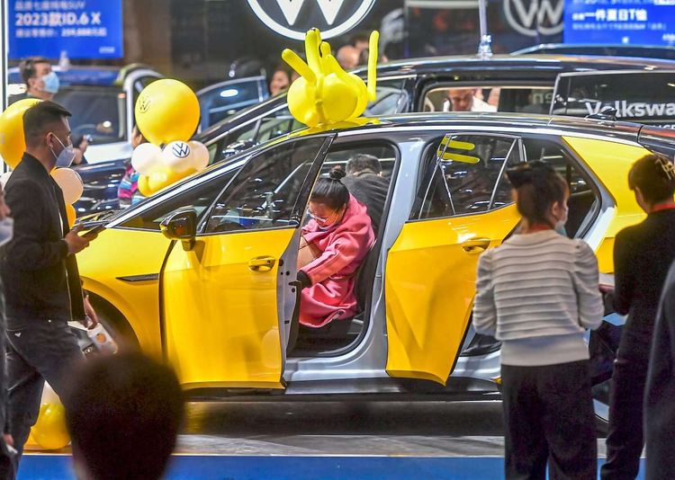 Besucher und Besucherinnen begutachten einen Volkswagen ID.4 Elektro-SUV während der Xinjiang International Auto Show.
