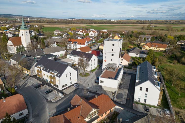 Eine Luftaufnahme auf das Ortszentrum von Markersdorf-Haindorf, in der Mitte ist der neu gestaltete Lagerhausturm zu sehen, auf der linken Seite der Kirchturm.