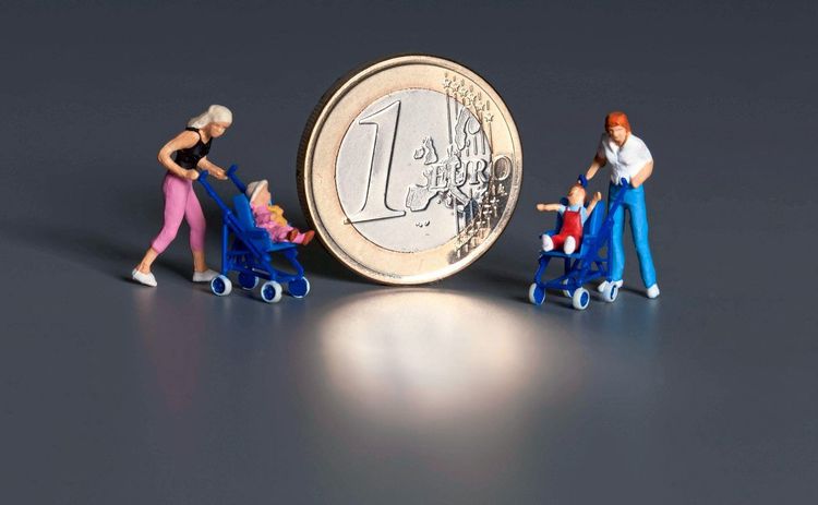 Figuren von Eltern mit Kinderwagen; in der Mitte eine Euromünze.