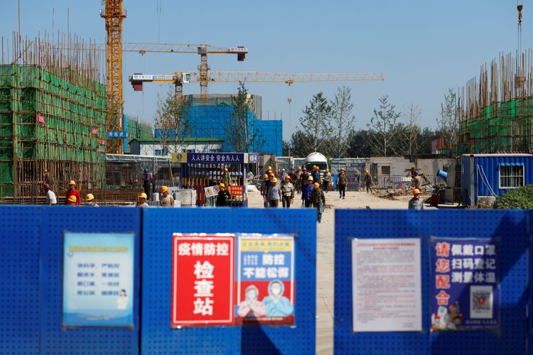 Arbeitende gehen über eine Baustelle der chinesischen Evergrande-Gruppe in Peking