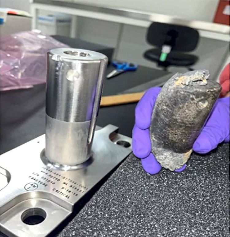 Zylindrisches Objekt von ISS in Hand wird untersucht. 