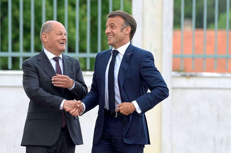 Deutschlands Bundeskanzler Olaf Scholz (SPD) und Frankreichs Präsident Emmanuel Macron scherzen miteinander
