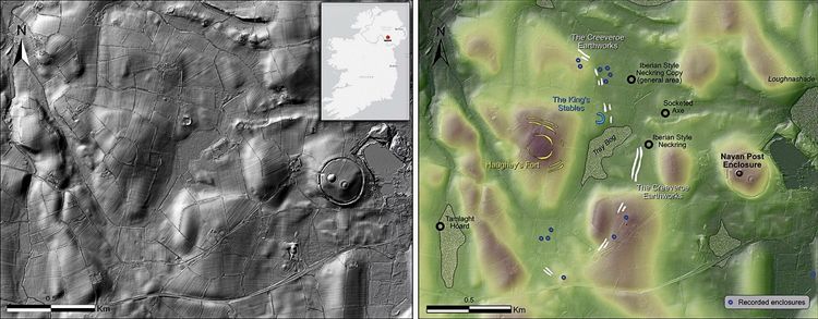 LiDAR- und magnetometrische Karten einer historischen Stätte in Irland, die ein großes proto-urbanes Zentrum zeigen. Links ist eine Graustufen-Reliefkarte mit Geländedetails, während rechts eine farbige Karte mit Geländestrukturen und markierten Funden zu sehen ist, darunter „Haughey's Fort“, „The King's Stables“ und weitere archäologische Aspekte. Ein Maßstabsbalken sowie eine Lagekarte sind ebenfalls enthalten.