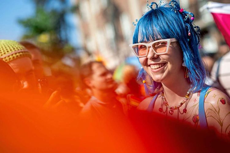 Eine junge Frau bei einem Festival mit blau gefärbten Haaren