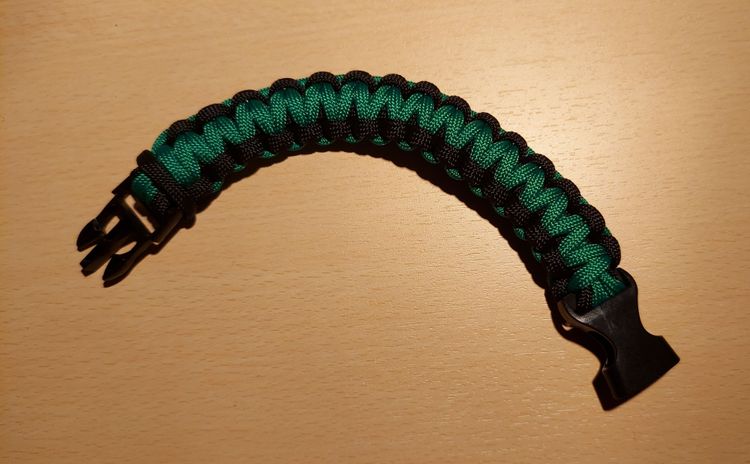 Foto von einem schwarz-grünen Halstuchanhänger mit Kobra-Muster