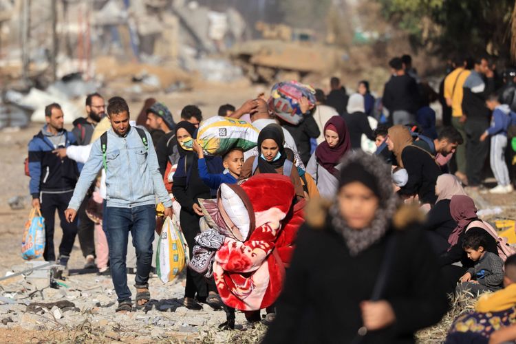 Flüchtlinge mit den nötigsten Habseligkeiten auf einer zertrümmerten Straße.