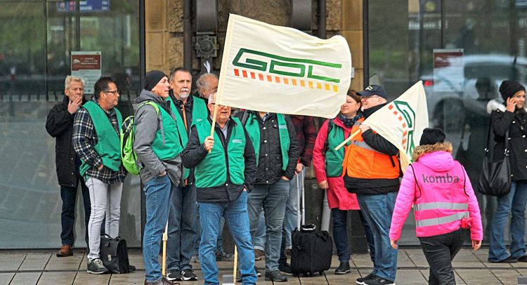 Lokführerstreikende halten GDL-Gewerkschaftsflagge hoch.