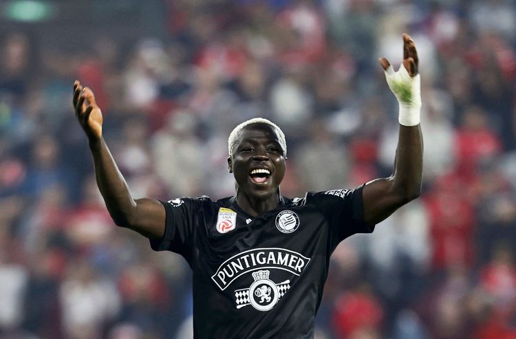Ein Fußballspieler des SK Sturm Graz jubelt mit ausgebreiteten Armen auf dem Spielfeld. Er trägt ein schwarzes Trikot mit der Aufschrift 
