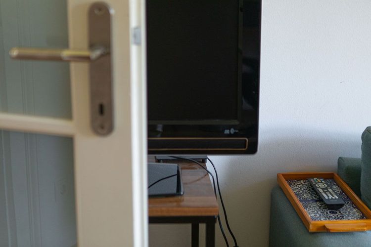 Auch eine Option: den Fernseher auf ein Wagerl stellen und nur hinter der Tür hervorholen, wenn er gebraucht wird.