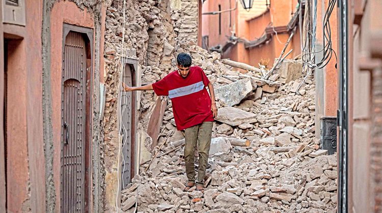 Ein Mann bahnt sich in Marrakesch seinen Weg durch Trümmer.