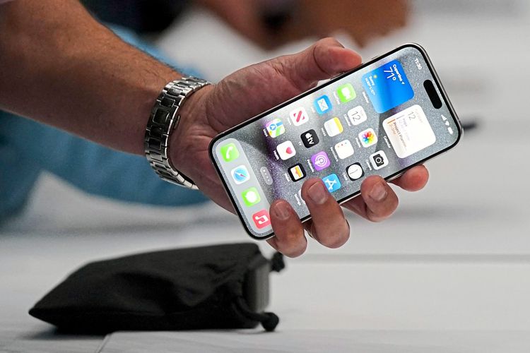 Das Bild zeigt eine Person, die ein iPhone 15 Pro in der Hand hält.